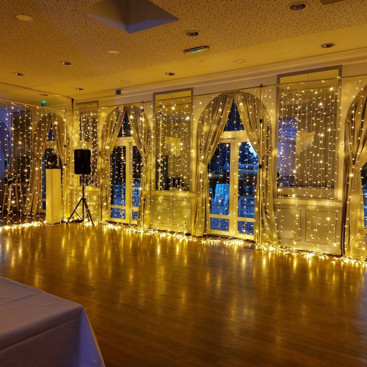 Salle de réception du Château d’Apigné décorée avec guirlandes lumineuses pour mariage en Ille-et-Vilaine