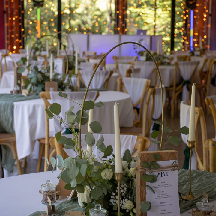 Décoration de table de mariage au Haras du Reuzel avec centre de table végétal et guirlandes lumineuses en Ille-et-Vilaine