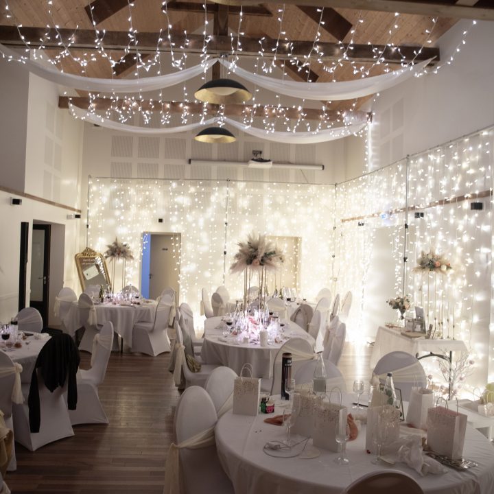 Salle de réception du Domaine des Hayes à Maxent décorée pour mariage avec ambiance chaleureuse et éclairage guirlandes