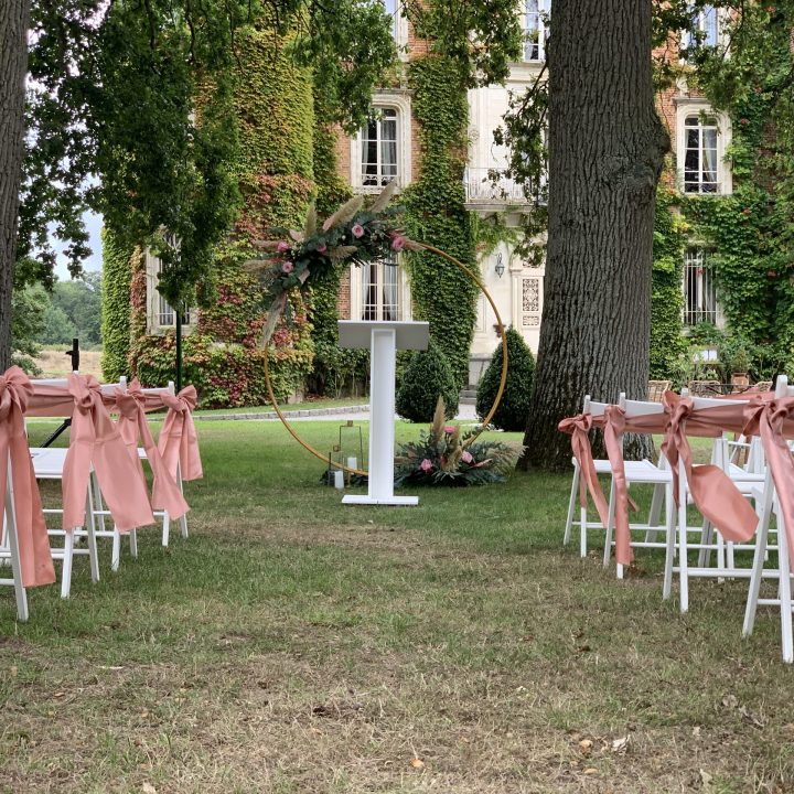 Cérémonie laïque dans le parc du Château d’Apigné avec arche fleurie et chaises décorées en Ille-et-Vilaine